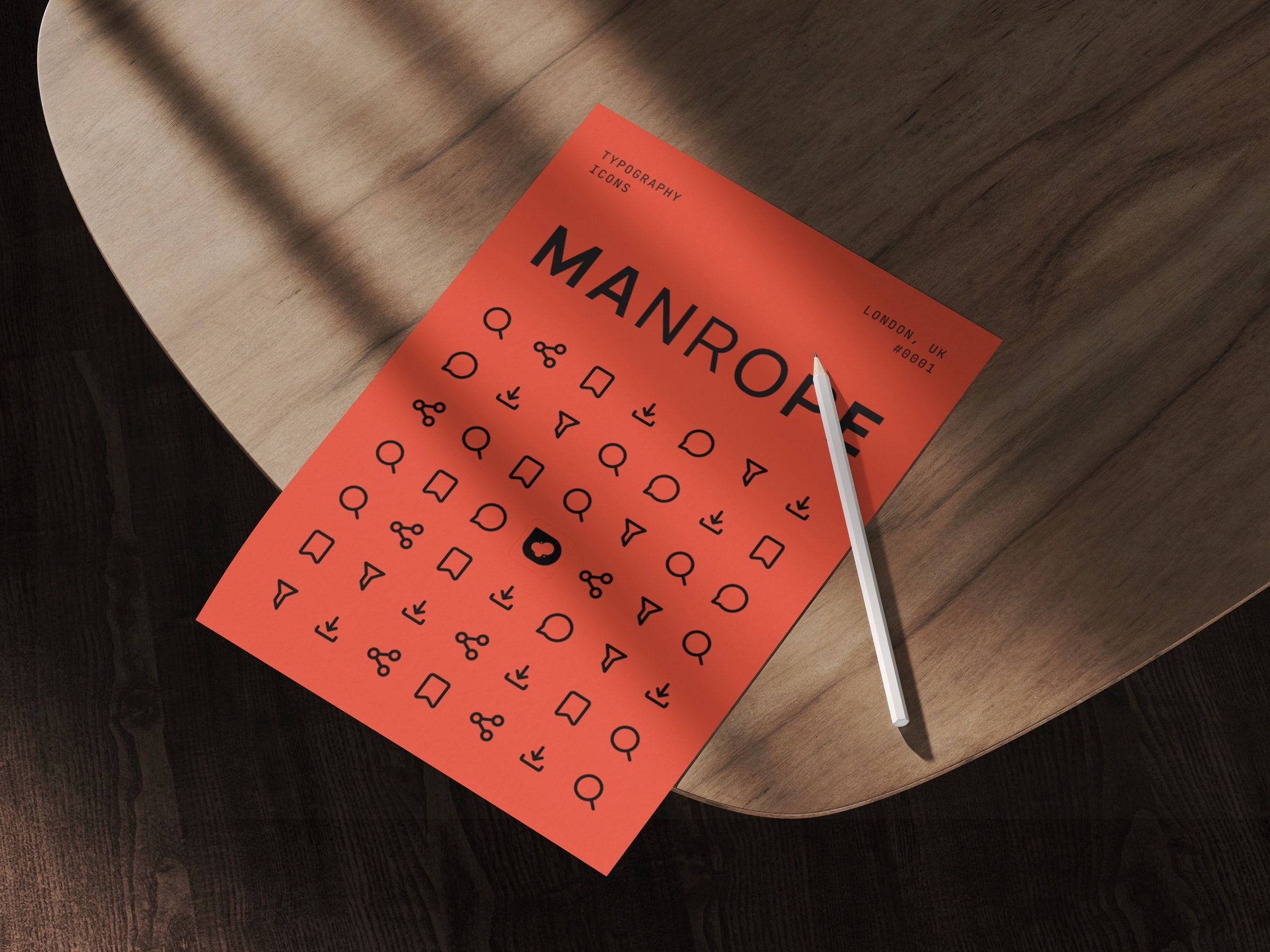 Printed vermilion specimen poster headed Manrope, Typography and Icons, carrying the Reelic glyph set in black, on a wooden table beside a pencil