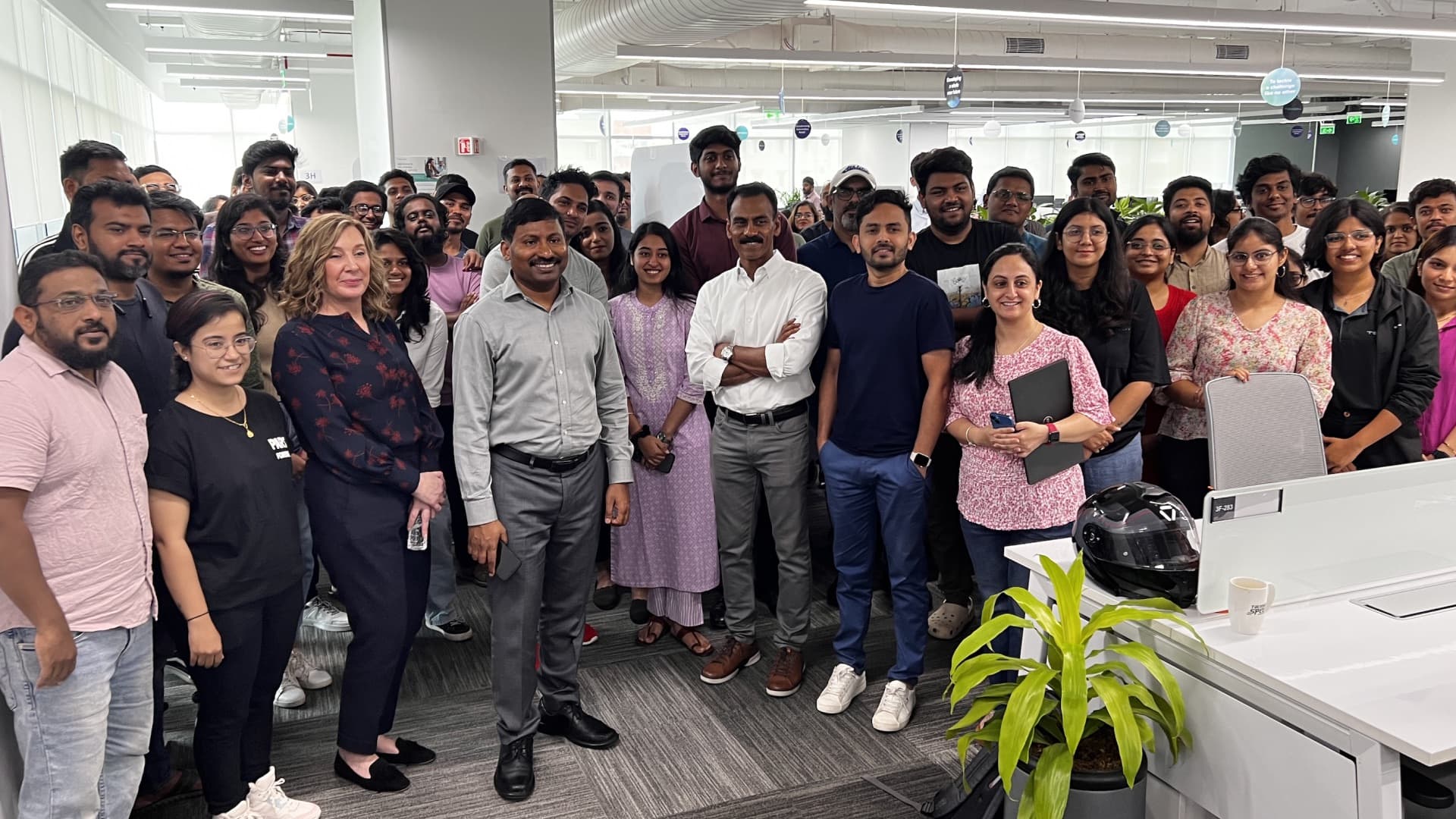 A large group photographed together between the desks in the Tekion office.